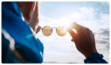man looking through sunglasses outdoors